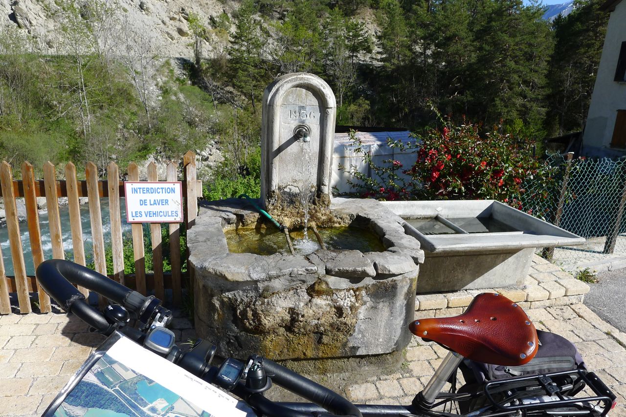 Fontaine dans le village d'Uvernet près du pont fleuris