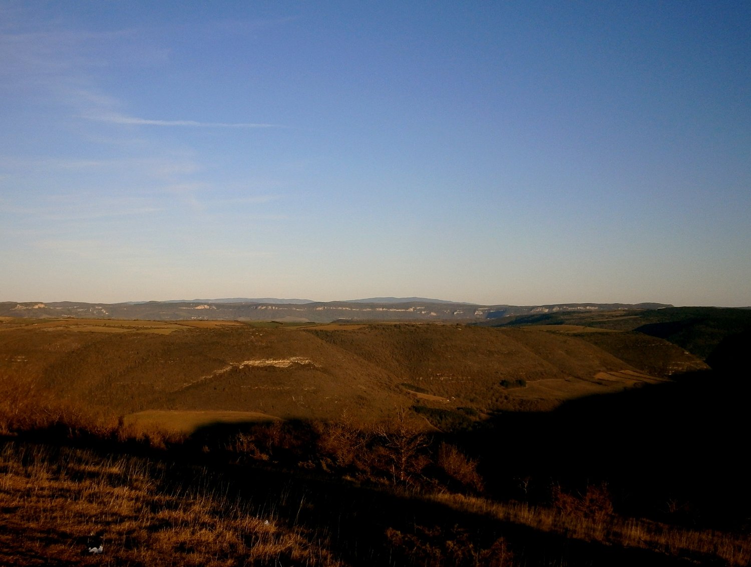 Par ordre d'apparition: La vallée de la Sorgues dévorée par l'ombre suivit de l'avant causse de Massergues puis le causse majeur du Larzac et enfin le massif de l'Aigoual avec le Pic de St Guiral à droite et l'Aigoual à gauche