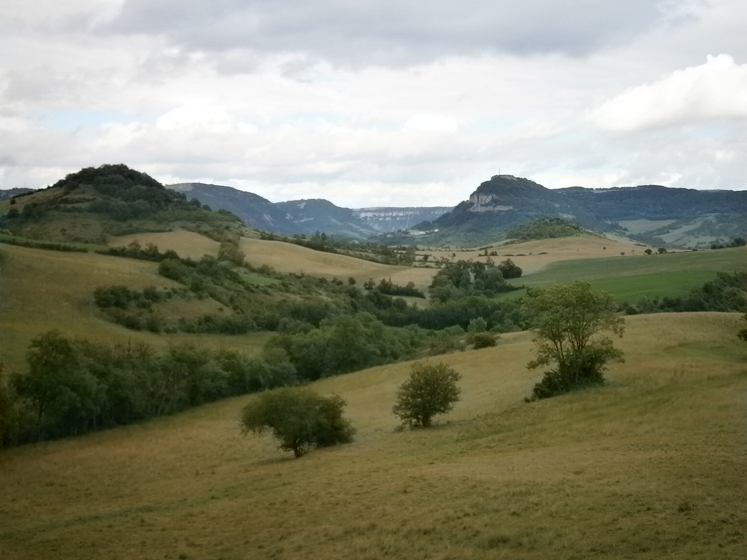 Au premier plan le petit volcan de Tiergue et en arrière plan le Combalou lieu d'affinage du Roquefort